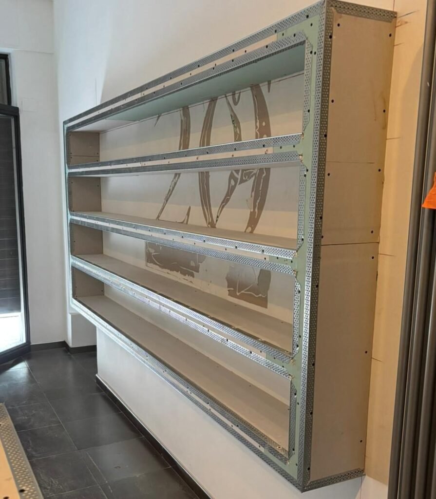 Opere d'arredo in cartongesso a Torino: struttura di una libreria su misura in cantiere con paraspigoli metallici di Absolute.